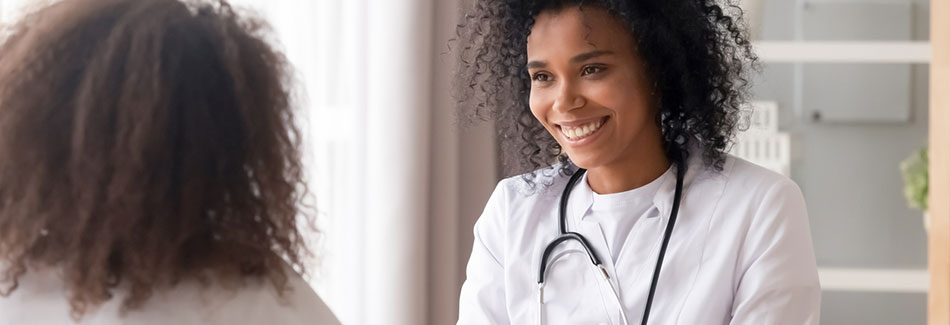 A doctor smiles as a teen patient who has visited the medical clinic