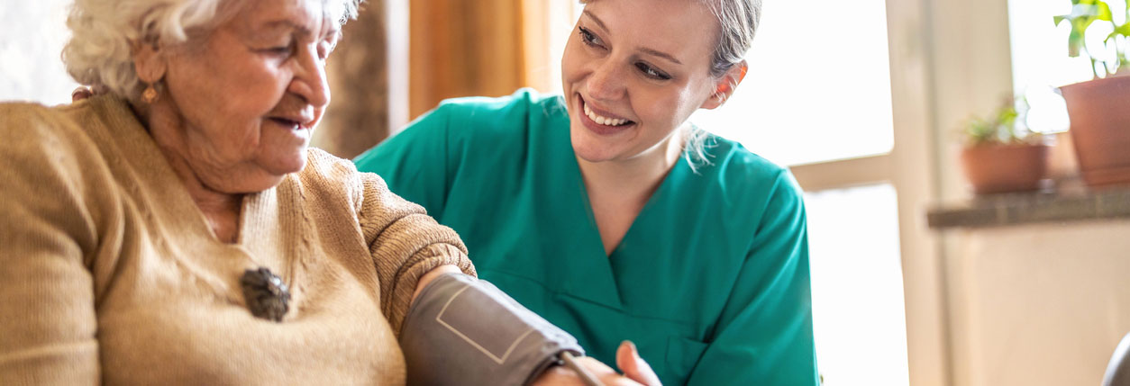 A nurse measures the blood pressure of a senior patient.