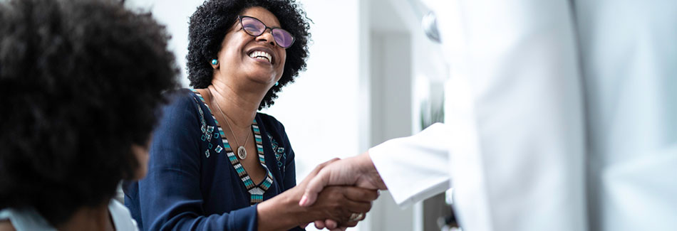 A doctor welcomes woman to hospital to discuss accepted insurance