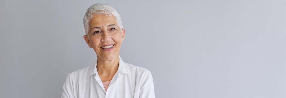 A doctor with short white hair smiles with her arms crossed at Carroll County medical clinic